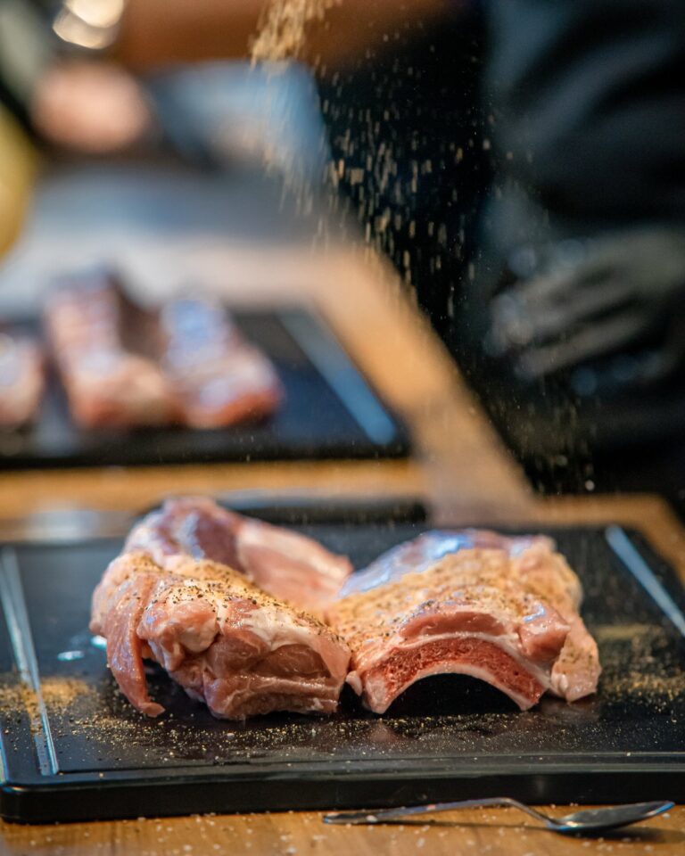 Dry Rub wird über rohe Ribs gestreut